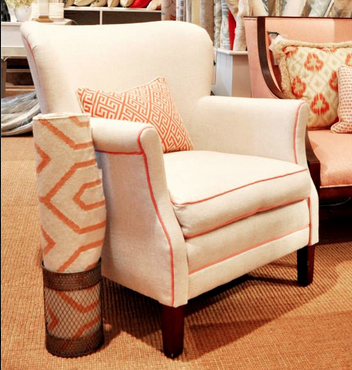 The pop of coral trim on this cream chair makes it a more interesting piece.